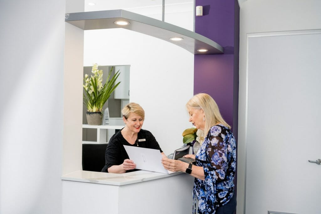 Michele Horst helping a patient at the Pennant Hills Dental Centre reception desk