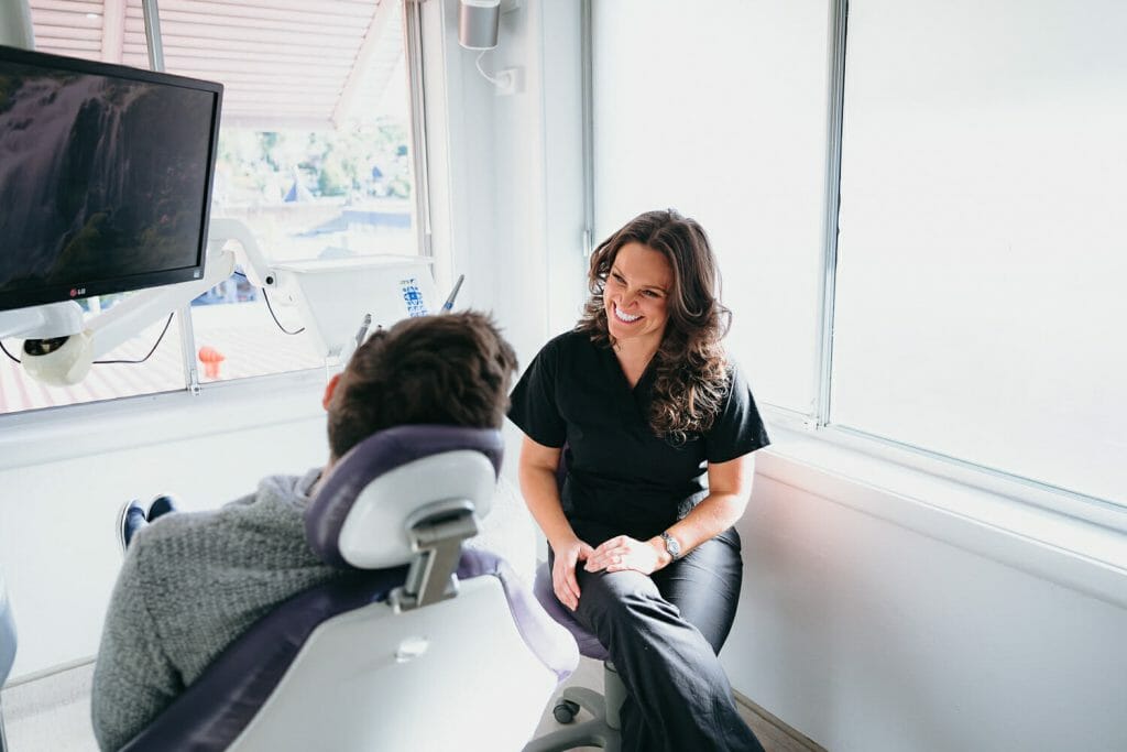 Dr Tirza Harley chatting with a patient in a dental chair