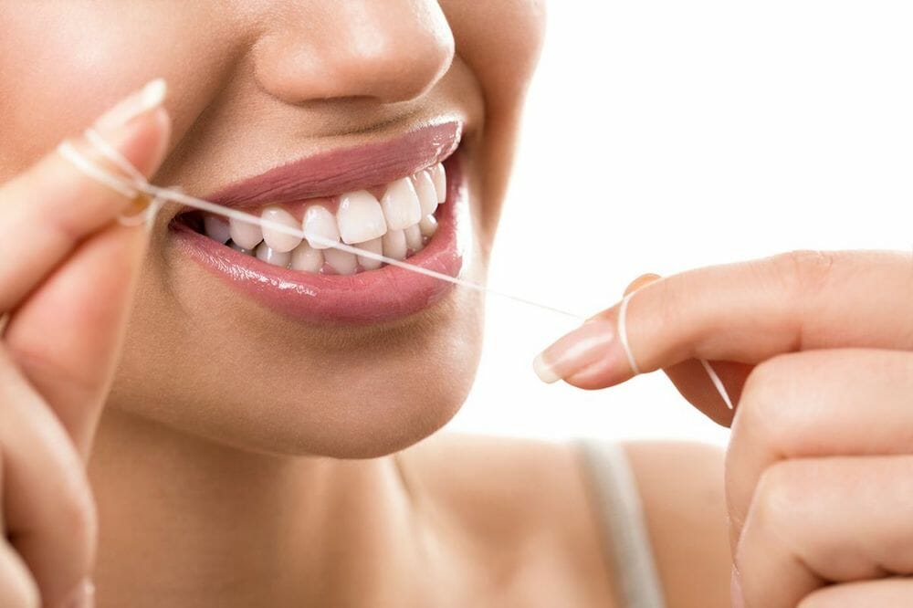 A woman flossing her teeth