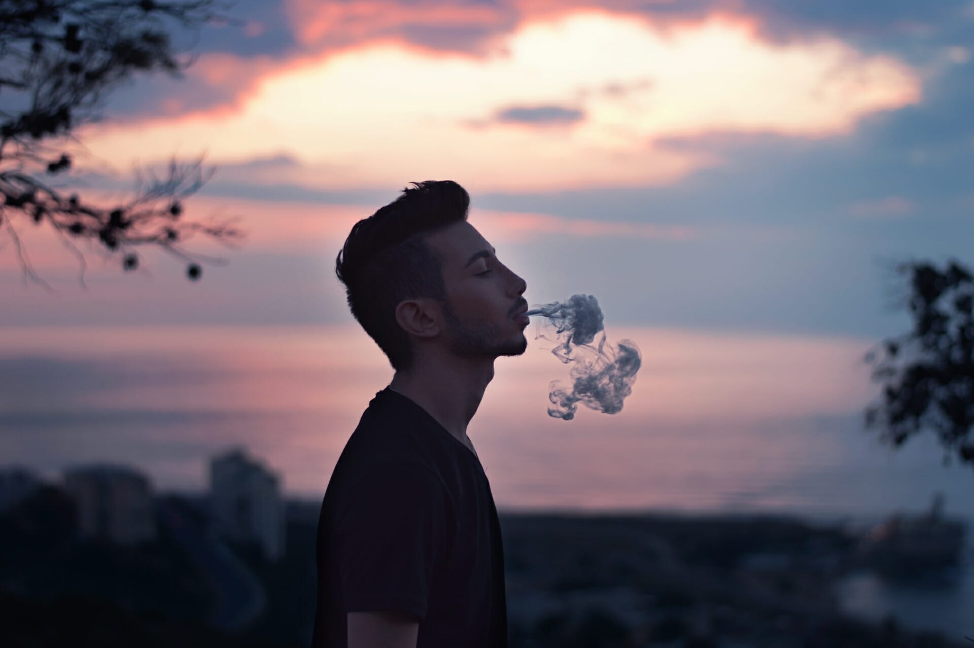 A young man vaping at dusk